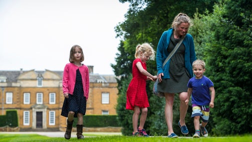 Family walking down the main drive at Upton House and Gardens, Warwickshire